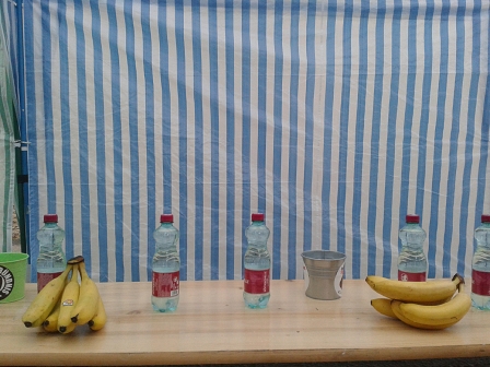 Bananen und Plastikflascher mit 0,5 Liter Wasser stehen auf einer Bierbank